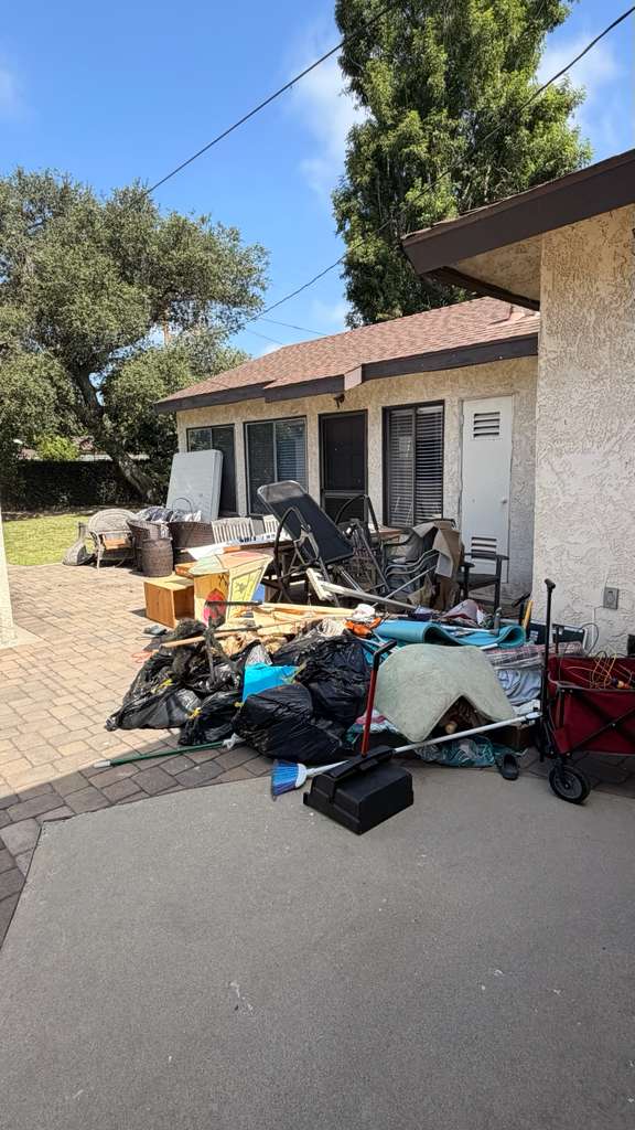 Cluttered residential garage in Long Beach packed with old furniture and appliances before junk removal